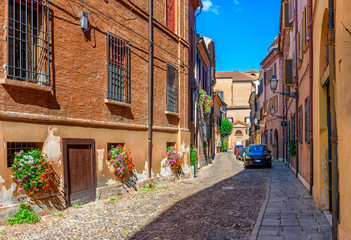 Fototapeta na wymiar Cozy narrow street in Ferrara, Emilia-Romagna, Italy. Ferrara is capital of the Province of Ferrara