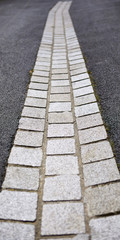 Abstract image of cobbled gully drain with tarmac sides sections.