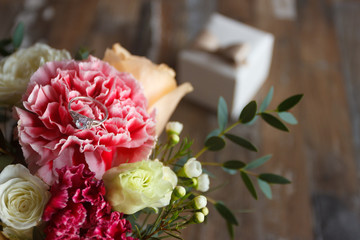 Silver ring and a bouquet of flowers, blurred background