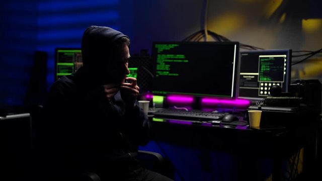Man hacker rolling tobacco in dark room