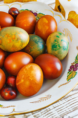 Easter eggs in a plate on an old white wooden background, retro style, rustic