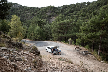 Liegen gebliebenes Auto in den Bergen mit drei Menschen