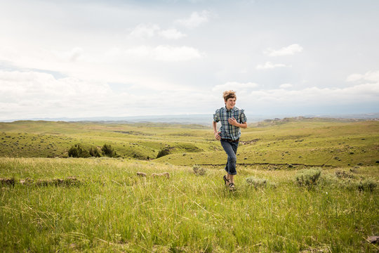 Young boy hiking through rural prairie setting. Cody, Wyoming, USA
