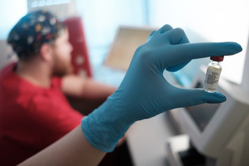 Female biologist holding bottle with new medication, vaccination lab research