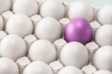 Easter purple red egg among many other identical white ones. the team leader or a loner., symbol of individuality. concept