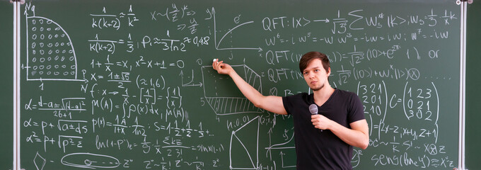 teacher of young professor explains the law of physics for students on the lesson, standing near...