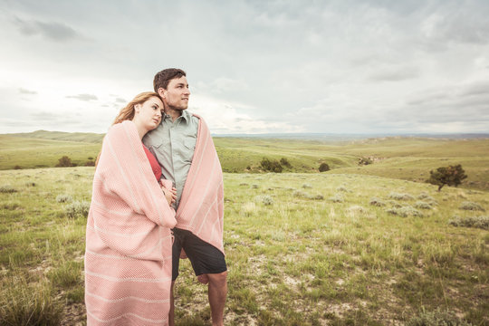 Couple dressed in vintage clothes hugging each other in a rural prairie setting. Cody, Wyoming, USA