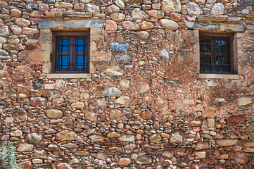 Windows in an old stone wall on the island of Crete in Greece.