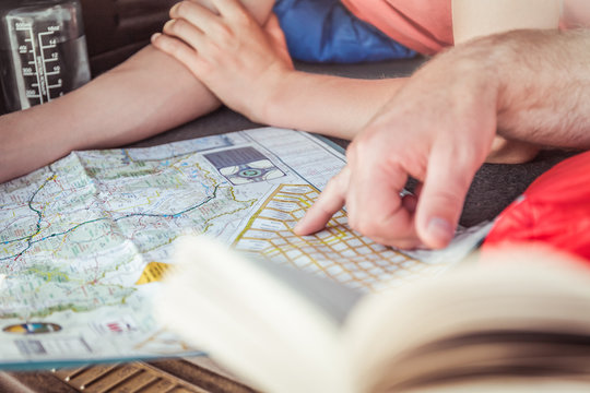 Close-up of father and son out in nature, camping in truck, reading map. Bridger, Montana, USA