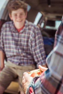 Close-up of father and son out in nature, camping in truck, aeting apple. Bridger, Montana, USA