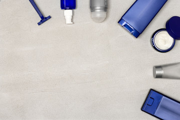 Cosmetics for men flatlay with copy space. Male grooming cosmetic products on gray cement background. Top view, flat lay