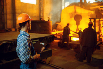 Master looks on steelmaking process in furnace