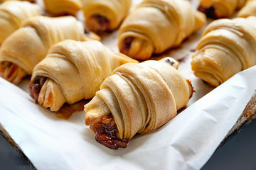 Homemade baking. Freshly baked hot sweet rolls stuffed with piled on parchment paper, on a baking sheet.