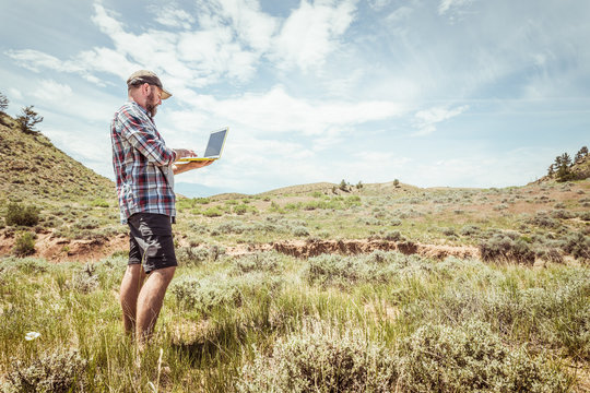 Man surveying and studying a rural prairie setting. Bridger, Montana, USA