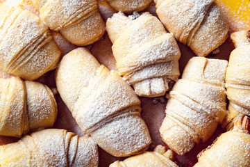 Homemade baking. Freshly hot sweet rolls with filling sprinkled with powdered sugar and stacked on a plate.