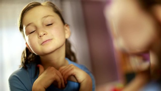 cute girl sitting and looking in the mirror. Teenage complexes. zits. unhappy with her appearance. making faces