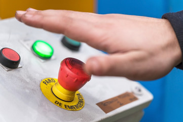 Hand pressing the red emergency button or stop button for industrial machine, Emergency Stop for Safety .