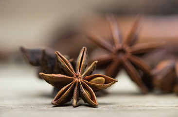 star anise with or without seed, closed, on a light wooden surface. spice for the recipe. beautiful...