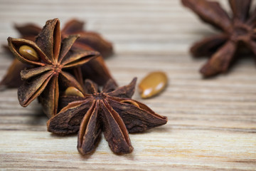 star anise with or without seed, closed, on a light wooden surface. spice for the recipe. beautiful...