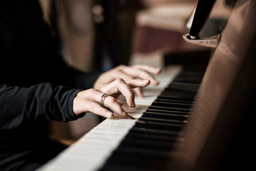 Young girl playing at home on the piano, selective focus on the girl's fingers. When playing the...