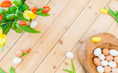 easter background decoration with eggs in wooden bowl, green leaves and tulip flowers on wooden floor. Spring decoration. Naturally designing sustainable