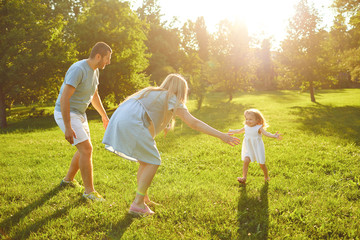Naklejka na ściany i meble Happy young family with children in the park