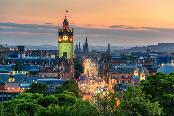 Balmoral's clock tower with Edinburgh cityscape skyline and Scott Monument background during sunset