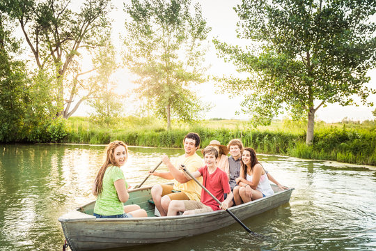 Group Of Young Adults Having Fun In A Swimming Lake While Rowing A Boat. Bridger, Montana, USATwo Young Adults Having Fun In A Swimming Lake. Bridger, Montana, USA