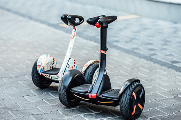 Whiteand black hoverboard or self-balancing scooter in the park close-up. Technology, future, copy...