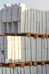 Construction Materials. Building materials for construction of residential complex. Pile of white bricks at construction site. vertical photo