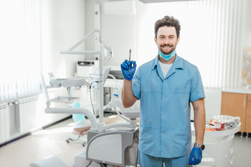 Fototapeta na wymiar Healthcare, profession, stomatology and medicine concept, male dentist over medical office background, holding syringe.