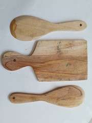 Two wooden spoons and a wooden cutting board with a white background.