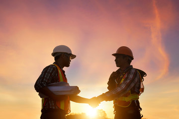 Construction engineers supervising progress of construction project stand on new...