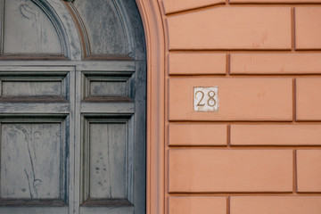 number 28, ancient house number plate on brick wall, Italy