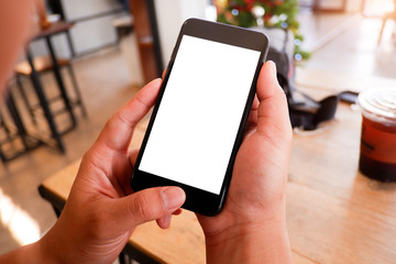 Mockup picture of business man’s hands holding smart phone with white blank screen in modern place.
