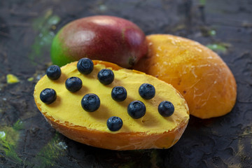 ice cream with mango pulp, garnished with blueberries,spanish ice cream in frozen mango fruit on a...