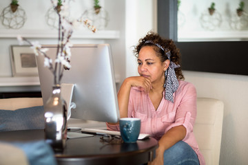 Mixed race woman working from her home office.