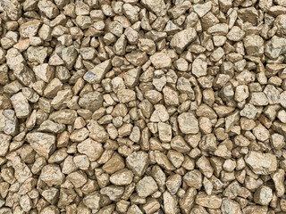 Compressed clean hardcore rock being used for the foundation for a new patio in the garden of a residential house