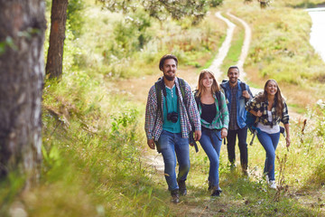 A group of travelers with backpacks is walking in nature