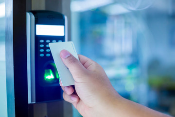Door access control. Staff holding a key card to lock and unlock door at home or condominium. using electronic card key for access. electronic key and finger scan access control system to unlock doors