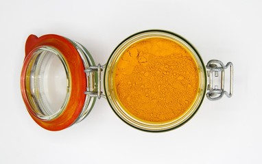 Top view on opening of isolated preserving glass jar with red rubber ring and yellow turmeric curcuma powder, white blank background