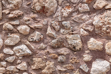 Stone medieval wall. Stones hold together by clay solution.