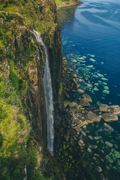 Mealt waterfall with Kilt Rock on the beautiful Scottish isle of Skye. Big waterfall on a sunny scottish day with deep blue sea in the background. © Anze