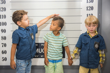 Elementary school boys playing police and prisoner. Children at indoor game center.