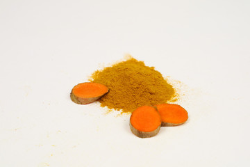 Turmeric powder and turmeric roots are isolated on a white background.It is used as a tonic for...