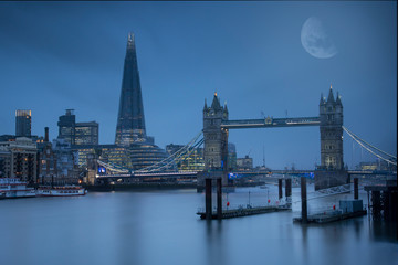 Naklejka premium Moon lit view over the Thames, taking in Tower Bridge, The Shard and City Hall