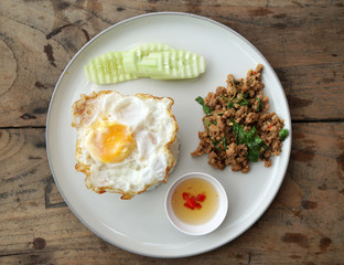 Thai food scene of Rice topped with stir-fried pork and basil and  Fried Egg