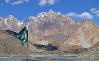 The Passu Cones or Cathedral Ridge, with Pakistan flag in front near Karakoram Highway in Passu,...