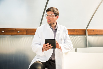 Portrait of biologist in empty greenhouse with tablet. Montana, USA