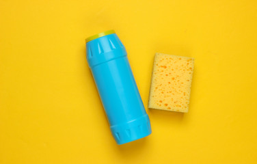 Ready for cleaning! Housework concept. Detergent bottle, sponge on a yellow background. Top view